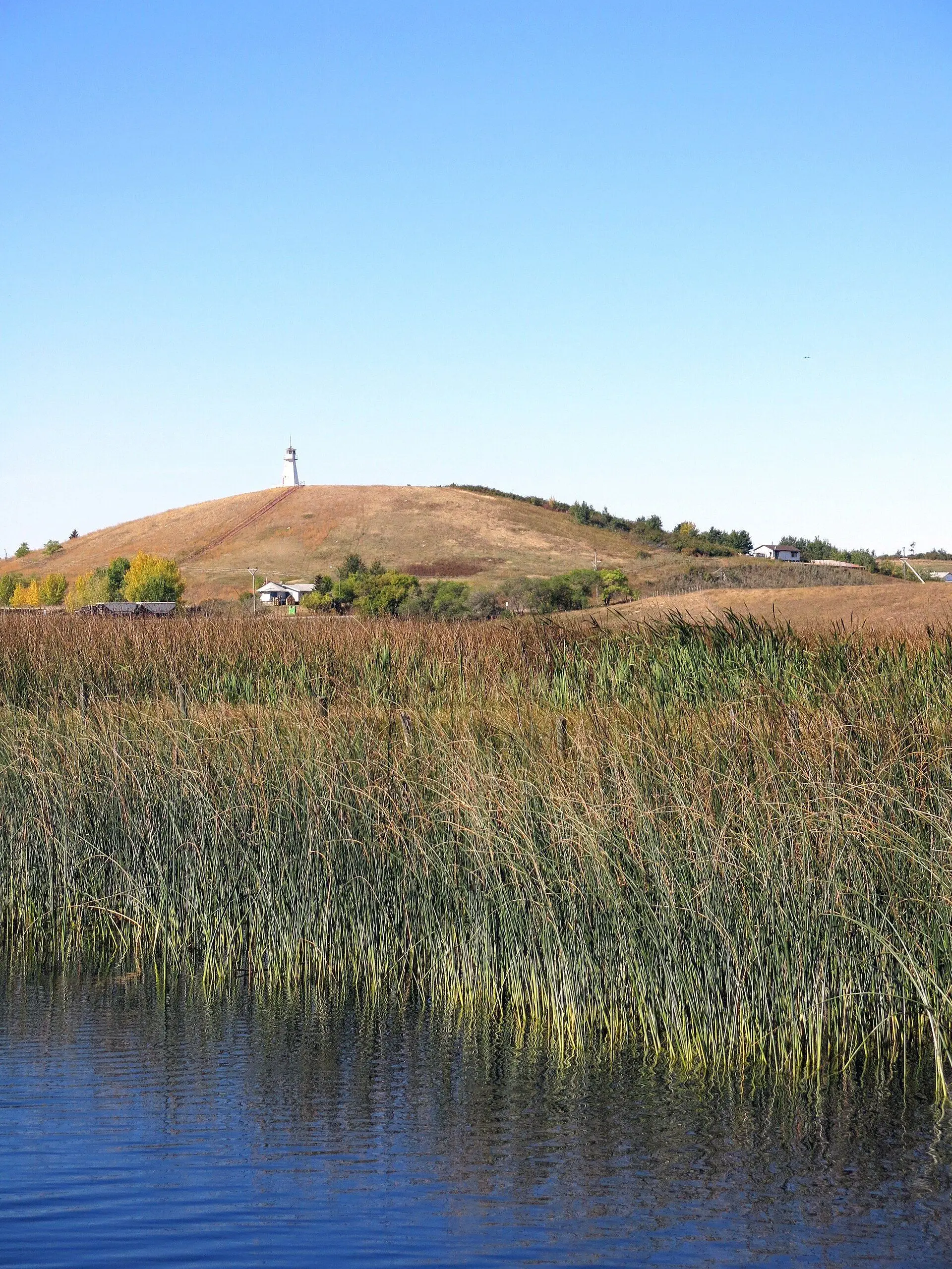 Reeds on Jackfish Lake with a hill and lighthouse-style tower